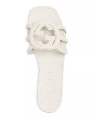 Side angle of white Gucci Mystic slides – clean, elegant sandals with embossed branding for women’s everyday wear.