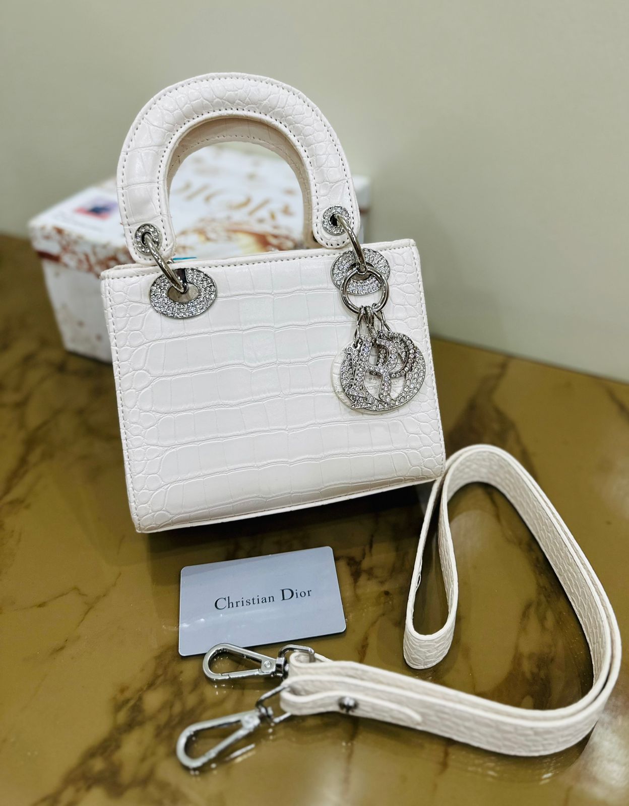 White Dior shoulder bag with monogram detailing and silver-tone accents for a chic look